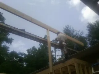 Carpenter setting a ridge beam over a new addition frame — Ice Dam Removal by Roofing Brothers in Carr