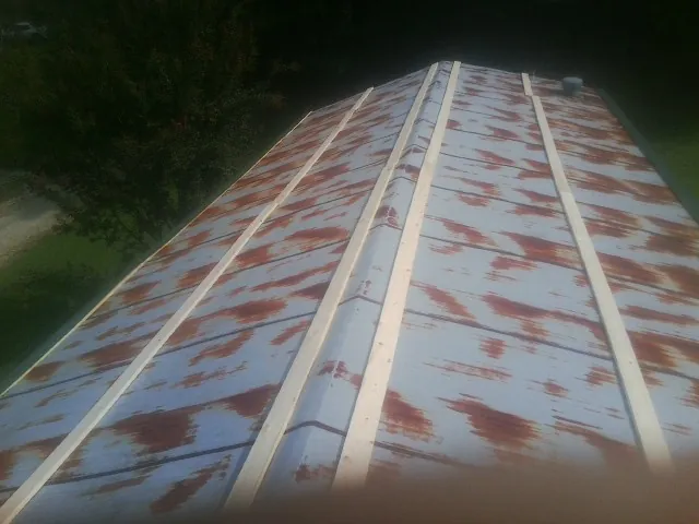 Rusted metal roof panels with new wood purlins before replacement — Storm Damage Roof Repair in Carr by Roofing Brothers
